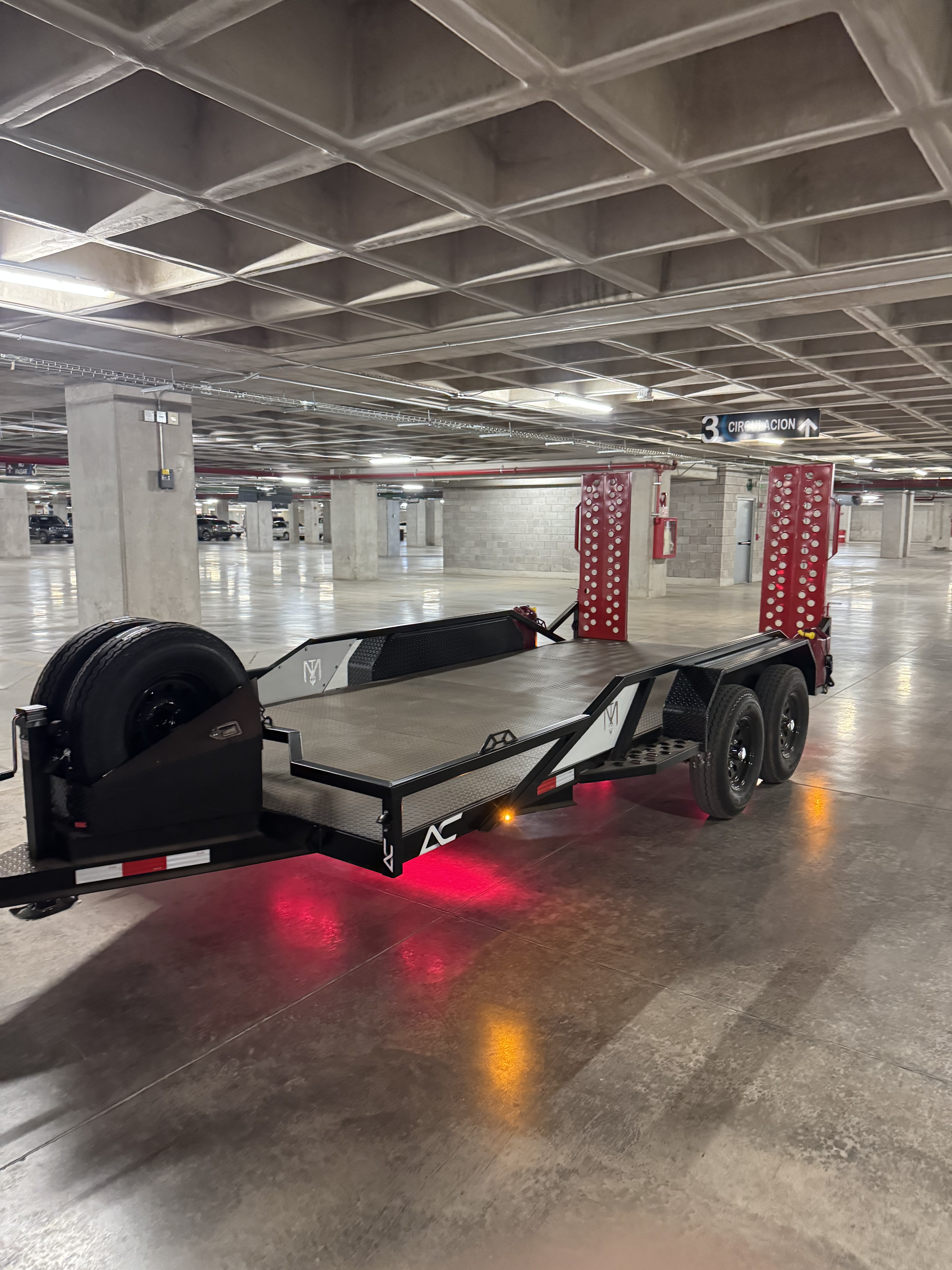 Custom ATV trailer hauling Can-Am off-road vehicles with mesh sides and tandem axle - AC Solutions custom fabrication