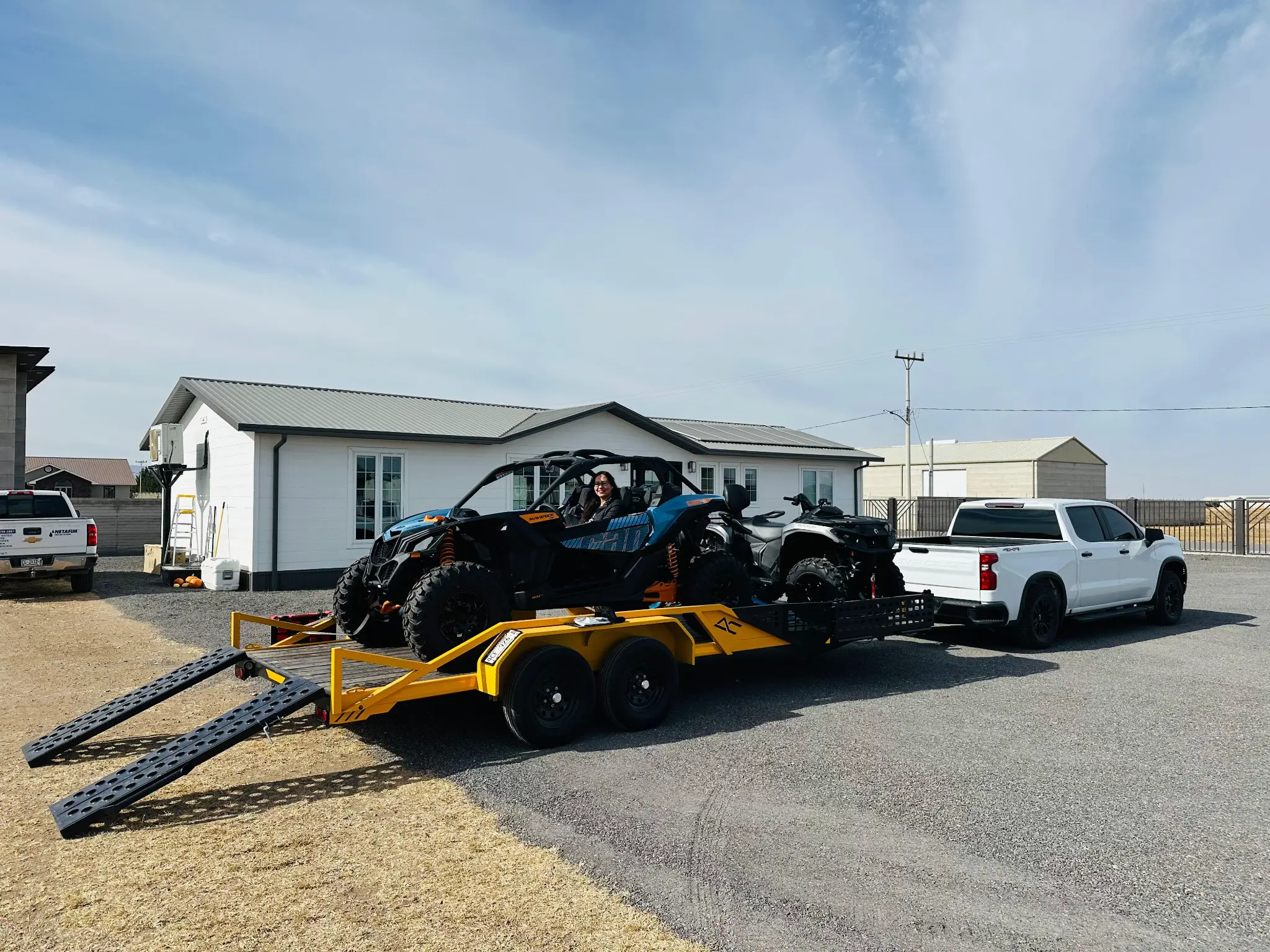Bright yellow custom trailer with Can-Am UTV and black loading ramps - AC Solutions custom fabrication